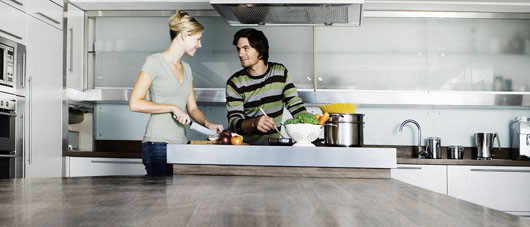 Young couple in modern kitchen, cooking together, smiling